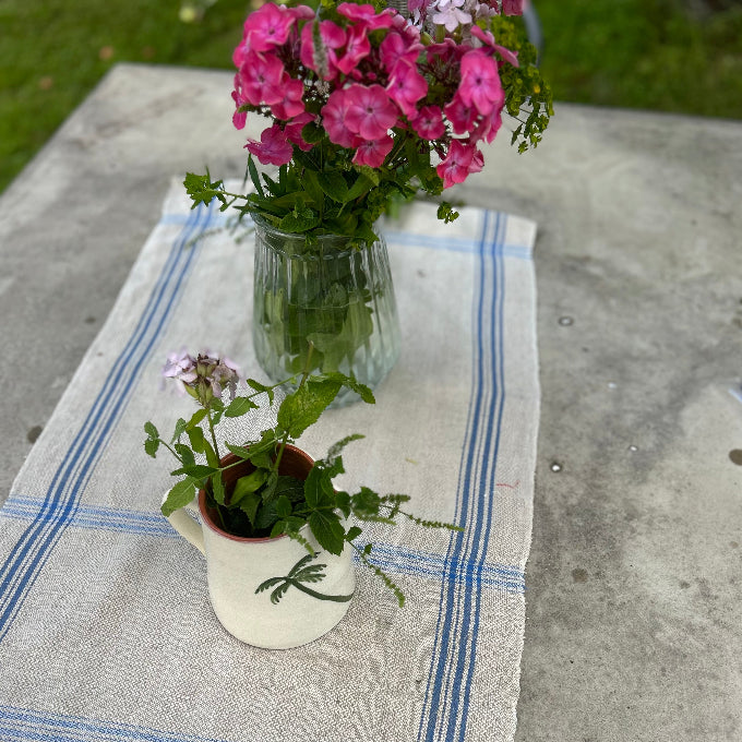 karaff i keramik med en blombukett